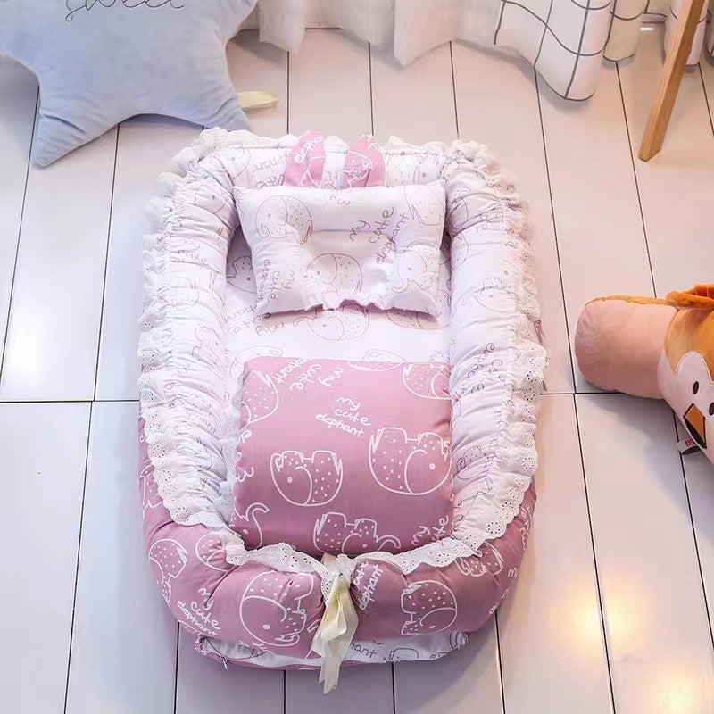 Pink baby crib with white lace trim