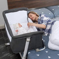 Woman lying next to a baby in a bassinet in a bedroom setting.