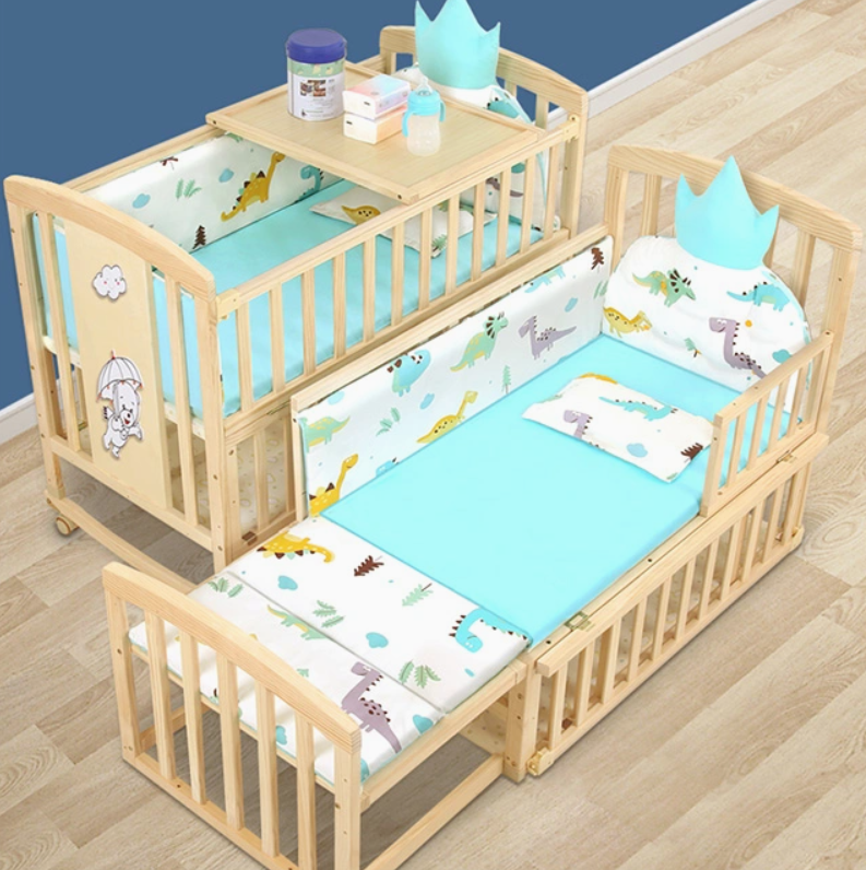 Wooden crib with baby bedding and accessories on a wooden floor.