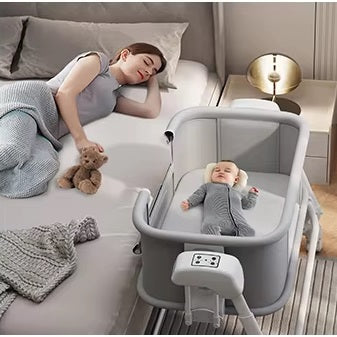 Woman lying on a bed with a baby in a portable crib 