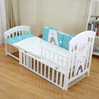 White crib with blue and gray bedding 