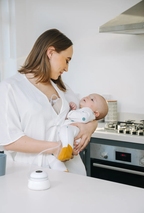 Woman breastfeeding a baby in 3 in 1 Double wearable Breast pump Revolution