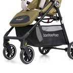Close-up of a baby stroller with an olive green and black seat liner, black frame, and a black mesh storage basket .