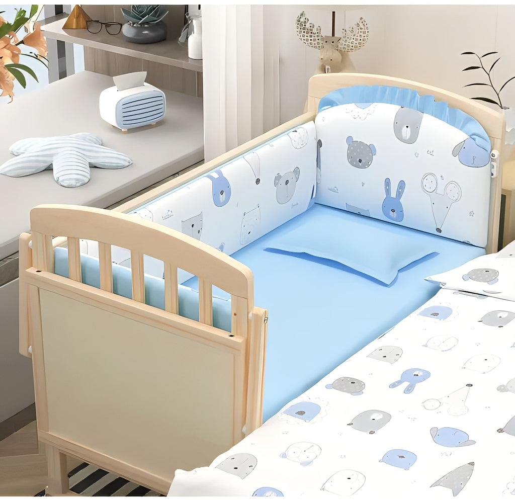 Children's crib with blue and white bedding featuring animal patterns.
