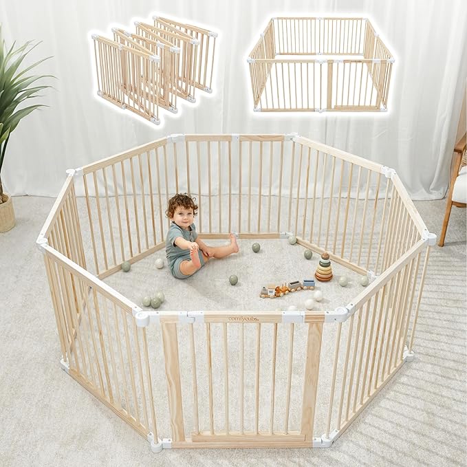 Child playing inside a wooden playpen with additional panels .