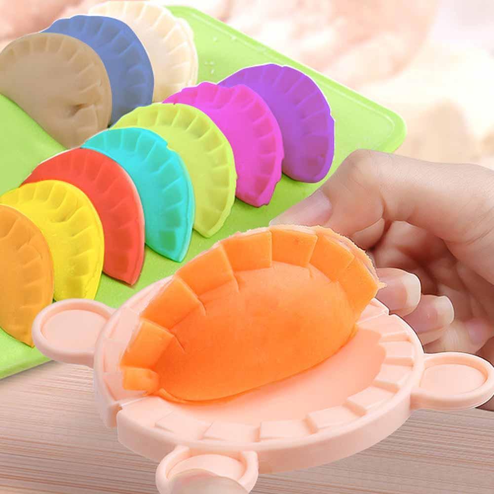 Colorful Gourmet  dumpling mold with a hand pressing dough into it on a wooden surface.