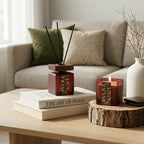 Decorative items on a coffee table including a wooden wild rose candle, diffuser, and books.