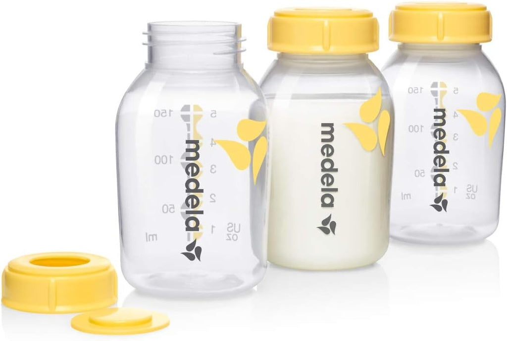 Three Medela breast milk storage bottles with yellow caps 