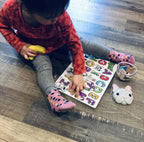 Child playing with a colorful alphabet puzzle with Melii container.
