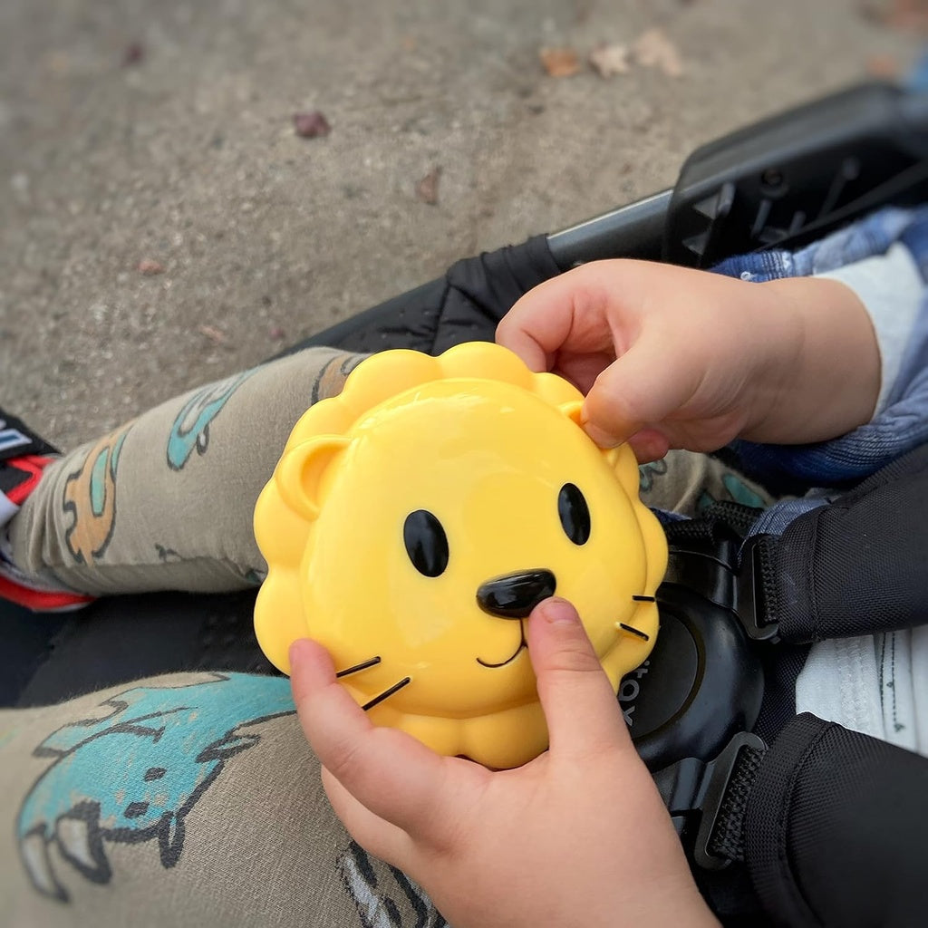 Yellow lion-shaped melliii container held by a child in a stroller