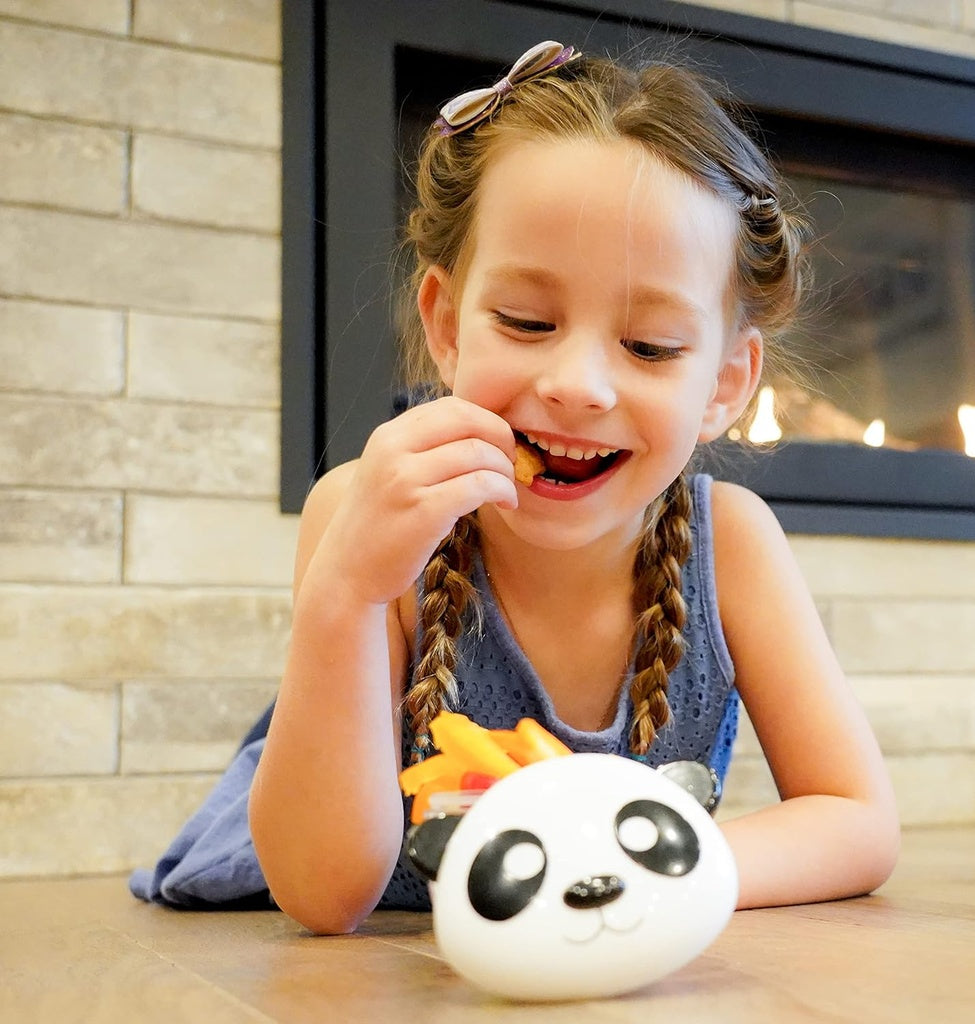 Young girl eating near a panda-shaped Meli Snack Container.