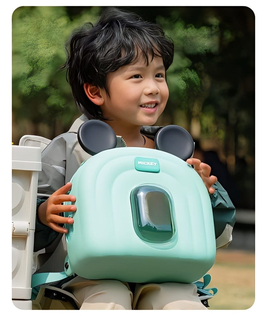 Child holding a green mickey mouse bag