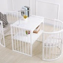White crib with round footboard .