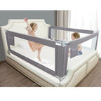 Children playing near a bed with a safety bedrail protector .