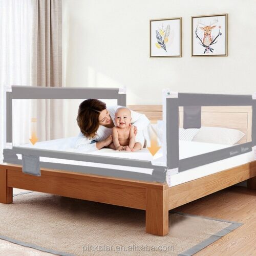 Baby being held by a woman in a bed with a safety portable bedrail.