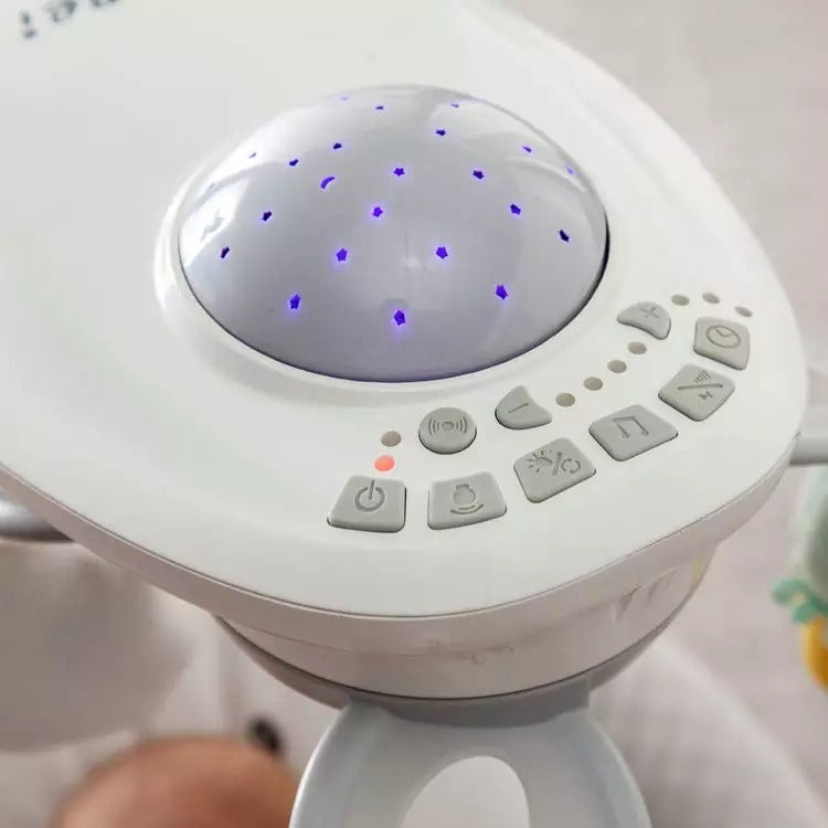 White electronic  musical bouncer with buttons and a starry night light .