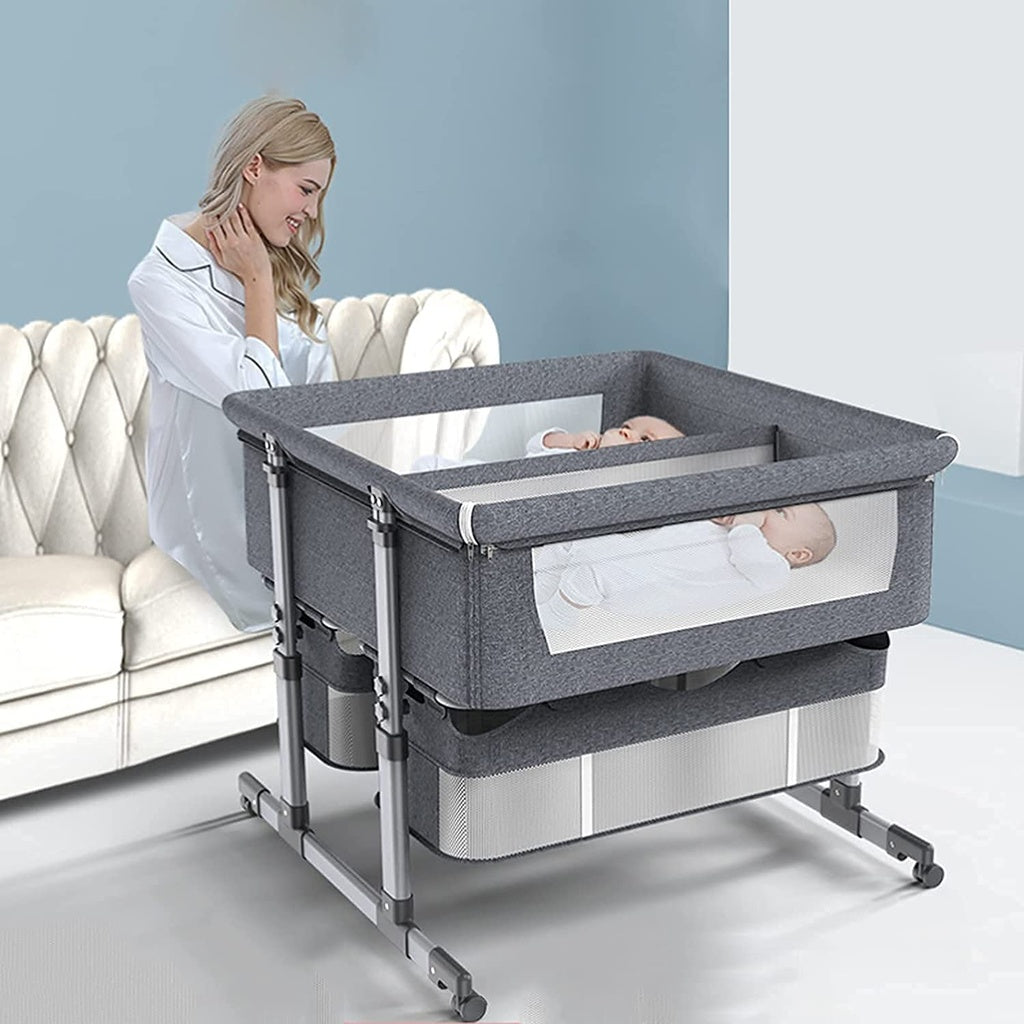 twin babies in a gray twin bassinet crib