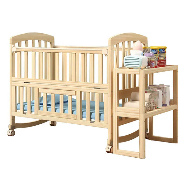 Wooden baby crib with blue mattress and adjacent changing table .!

