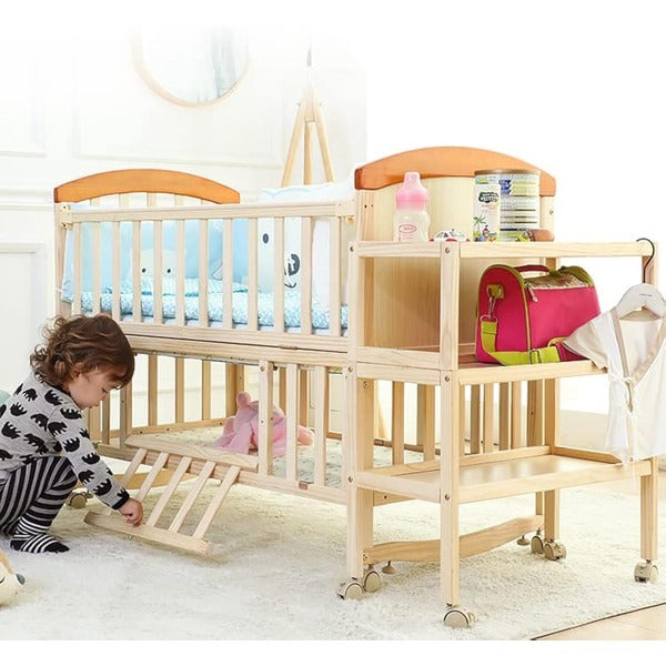 Child playing with a wooden crib and changing table set .