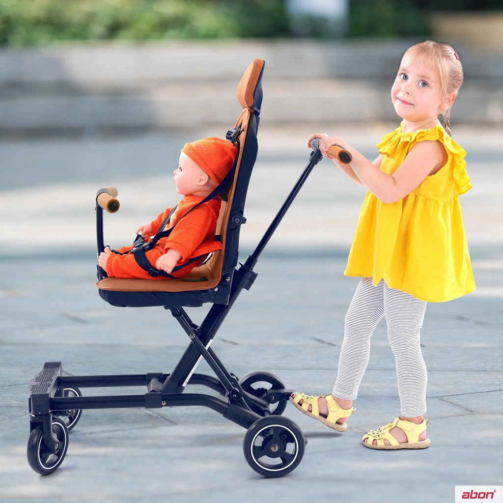 A young girl in a yellow dress pushes a convertible rider ll black stroller .