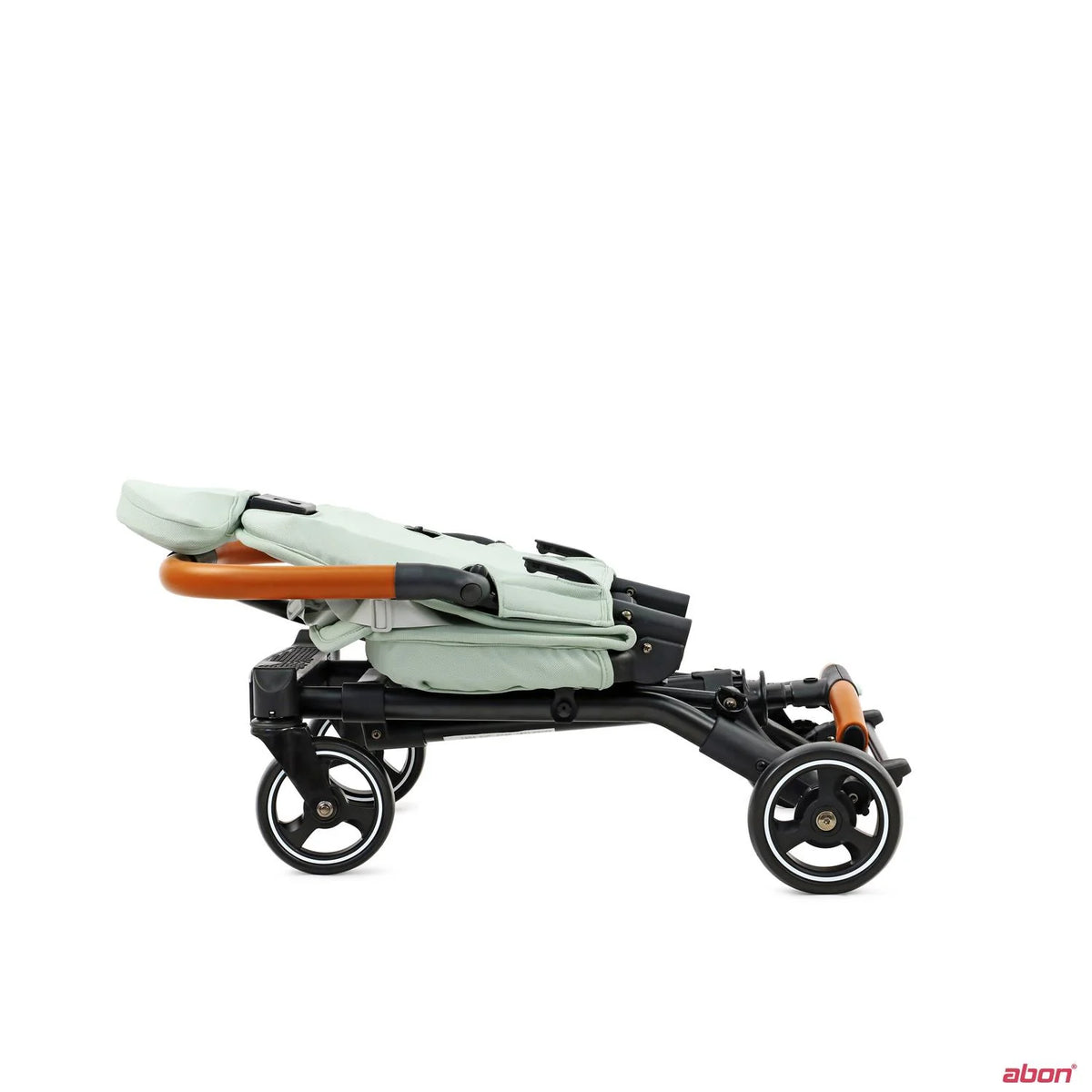 A folded Convertible Rider ll stroller shown from the side against a sage green fabric body, a black frame, and orange-brown handlebar accents.